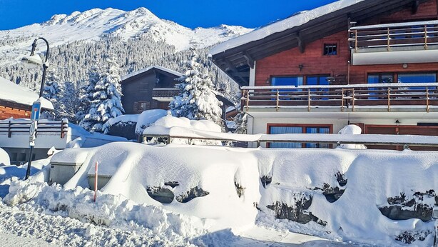A snow-covered mountain with a wooden cabin and a modern building with balconies. - Pigne 1 by Interhome (Verbier)