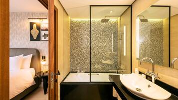 Un baño moderno con una bañera grande, una zona de ducha separada y un tocador con lavabo.