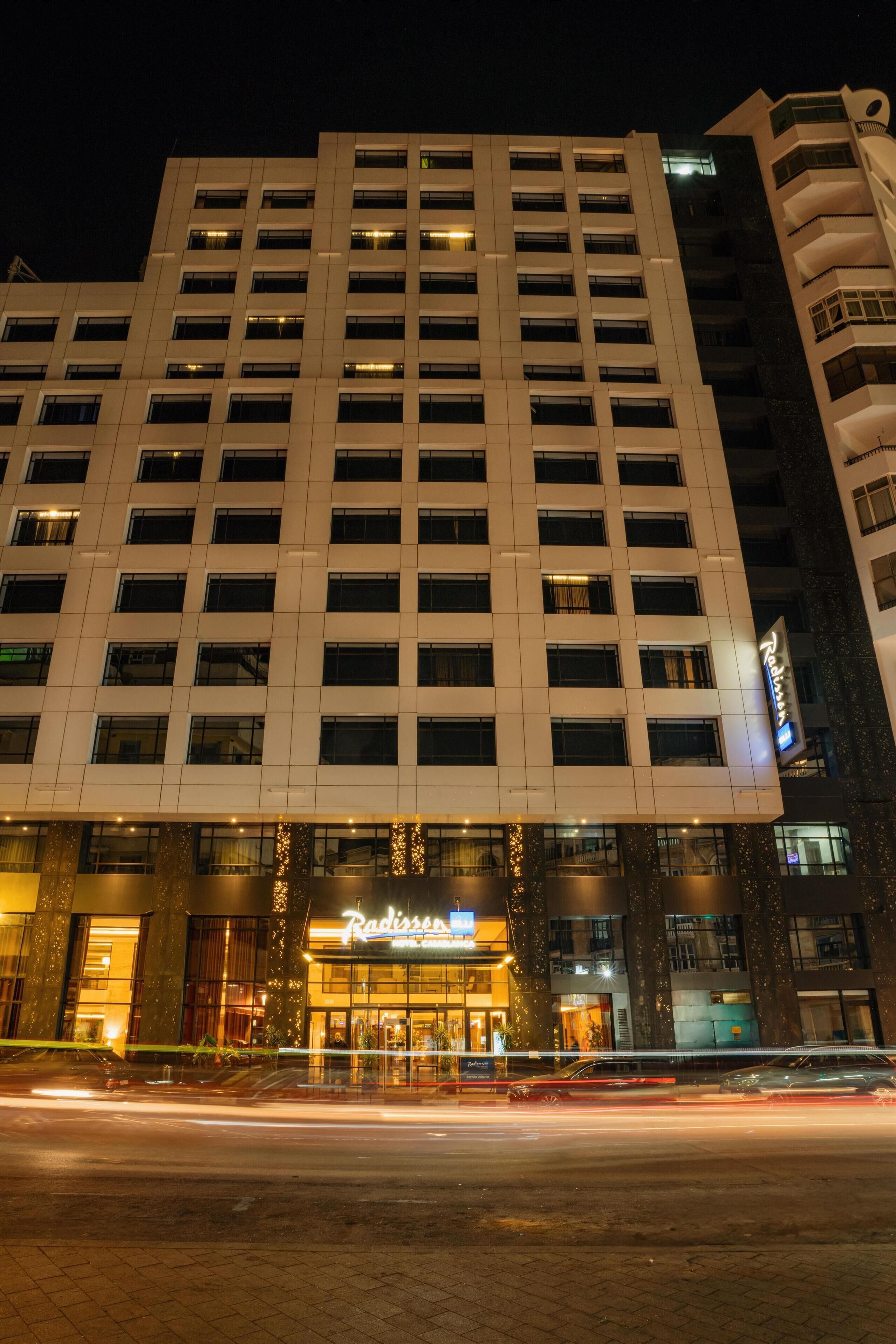 Ein mehrgeschossiges Hotel mit moderner Fassade, mit gut sichtbarer Beschilderung für 'Radisson'.