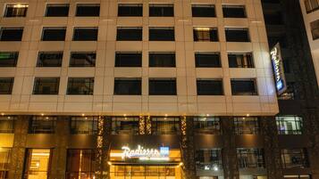 Ein mehrgeschossiges Hotel mit moderner Fassade, mit gut sichtbarer Beschilderung für 'Radisson'.