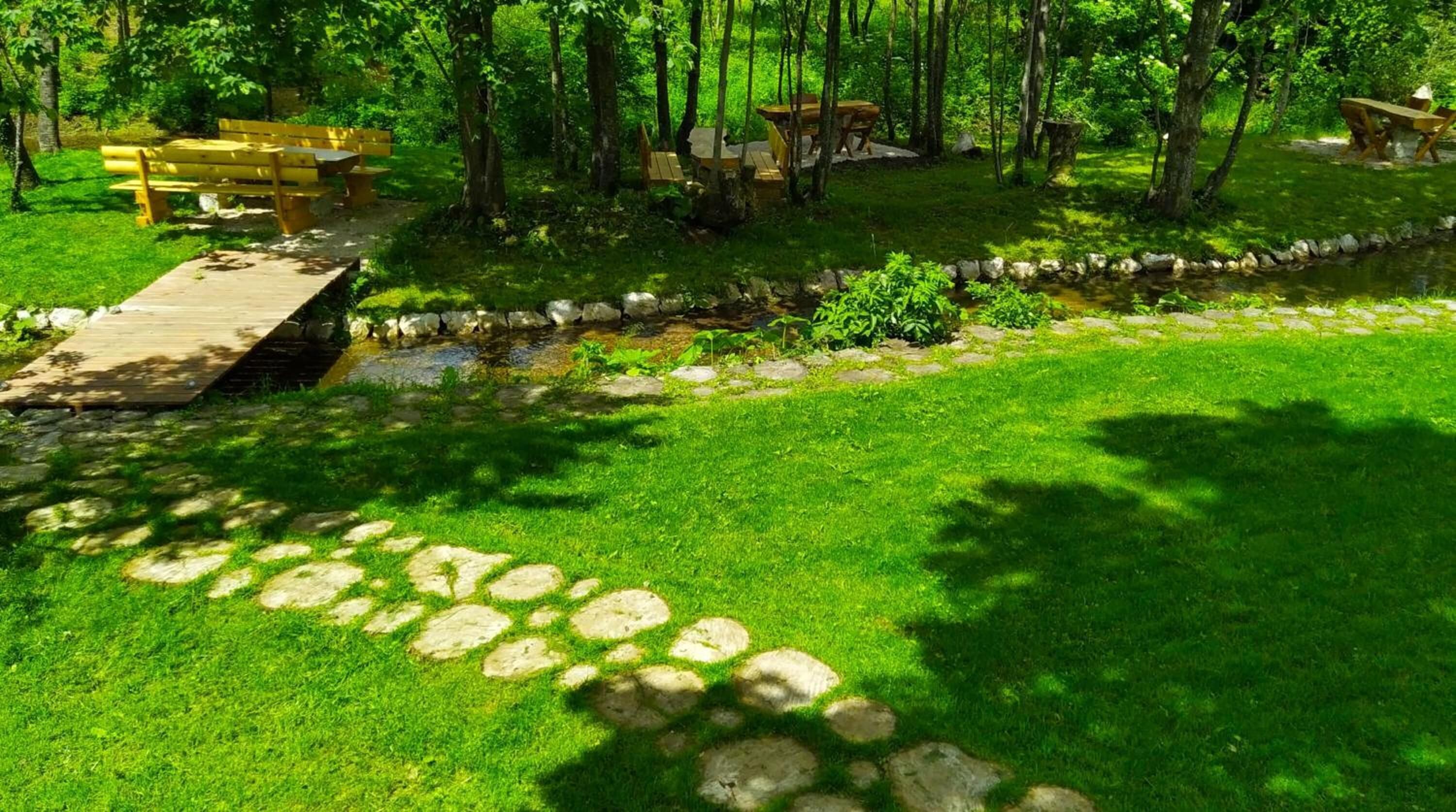 Un parc doté d’une terrasse en bois, de tables de pique-nique et d’un sentier pavé de pierres.