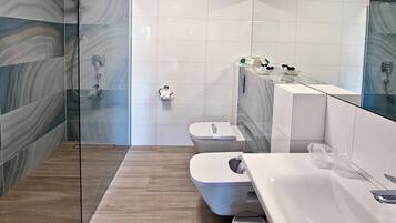 Ein modernes Badezimmer mit Duschkabine aus Glas, Toilette und Waschbecken.