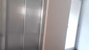 A hallway with a closed elevator door, a wall with a door, and a floor with a patterned mat. - Departamentos Balcarce (Balcarce)