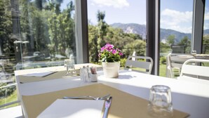 A dining table set with a menu, cutlery, a glass, and a potted plant. - Agriturismo Rossolampone (San Bernardino Verbano)