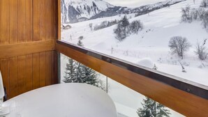 Una habitación con vistas a un paisaje montañoso nevado.