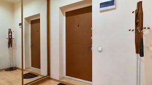 A hotel room with a large mirror, a wooden door, and a coat rack. - Home-Hotel Voloshskaya 51 (Kyiv)