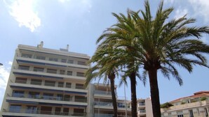 A multi-story building with balconies, a pharmacy, and parked cars. - Les allées du Cap by Interhome (Antibes)