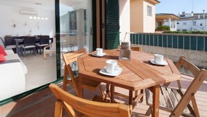 Una mesa de madera con cuatro sillas y un vidrio que da a un comedor.