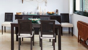 Un comedor con una mesa y sillas de madera oscura, un adorno en la pared y una ventana con vistas.