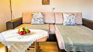 A cozy living area with a sofa, floral cushions, a table with fruit, and a painting on the wall. - Lueg ins Land by Interhome (Reith bei Seefeld)
