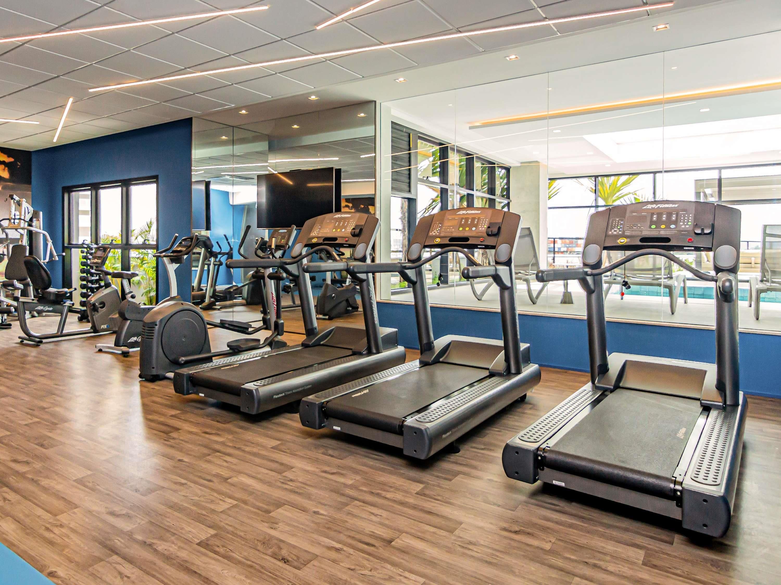 A gym with treadmills, stationary bikes, and weight machines.