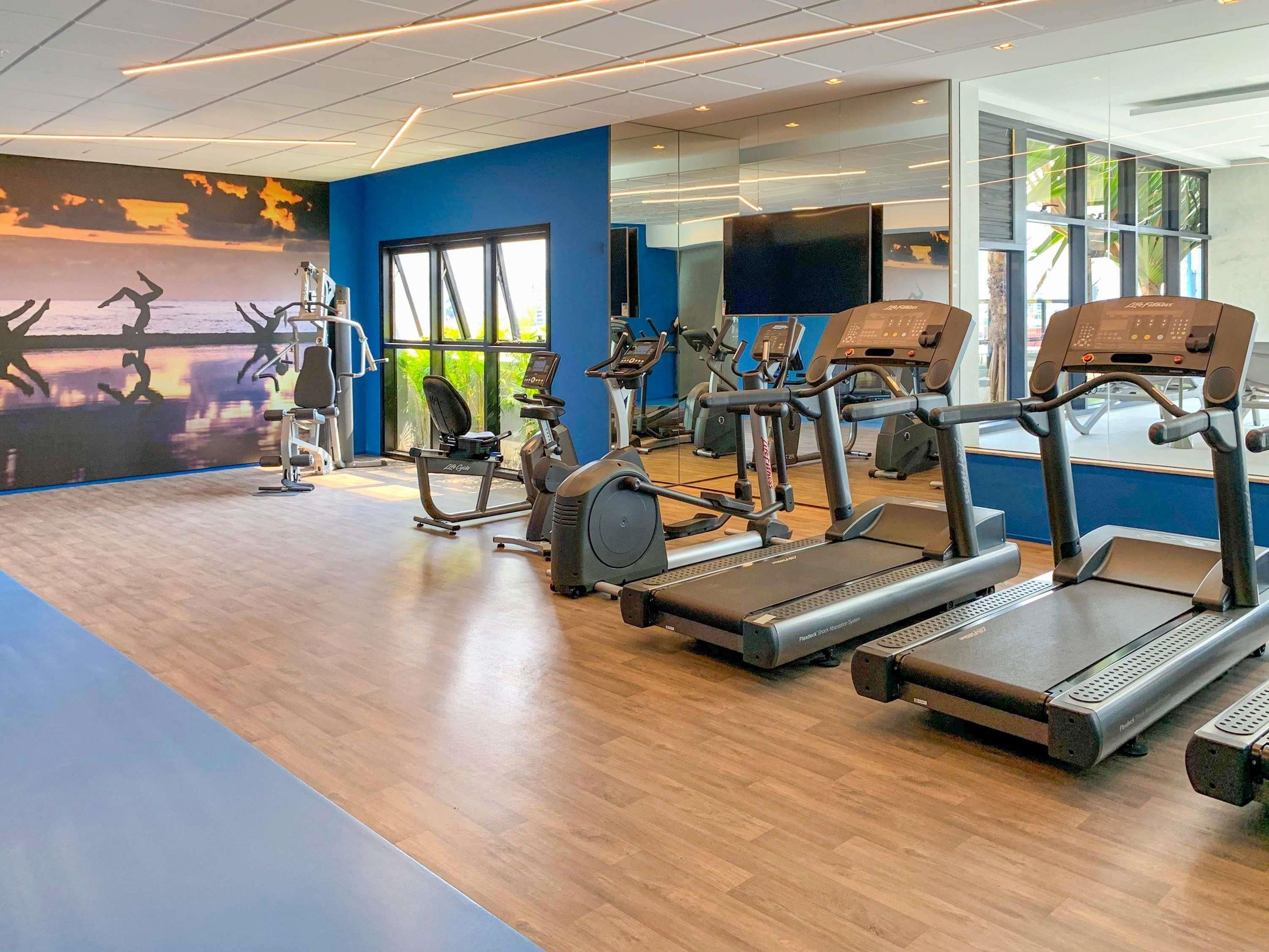 A gym with treadmills, elliptical machines, and stationary bikes.