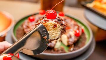 A dessert with a cherry on top, being served with a spoon.