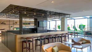 Een moderne bar met een centraal eiland, zitplaatsen en een groot raam met uitzicht.