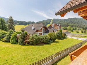 Un quartier résidentiel où les maisons sont entourées d’une végétation luxuriante et où l’on aperçoit des collines à l’arrière-plan.