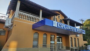 A hotel named "ESPLANADA HOTEL" with a balcony, air conditioning units, and a blue awning. - Esplanada Hotel (Paraguacu Paulista)