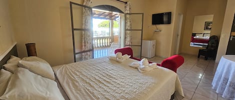 A hotel room with a bed, a TV, a desk, and a chair.