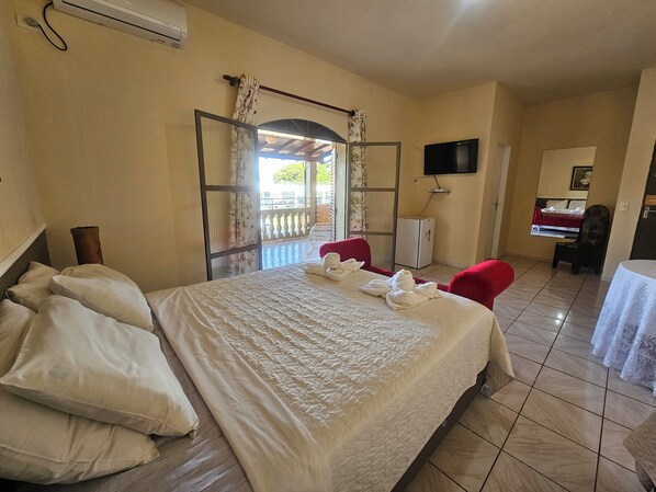 A hotel room with a bed, a TV, a desk, and a chair.