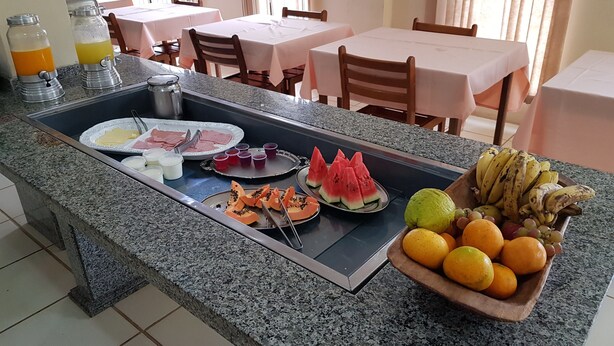 A breakfast buffet with various fruits, vegetables, and beverages. - Esplanada Hotel (Paraguacu Paulista)