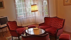 A living room with a red sofa set, a glass coffee table, and a TV on a stand. - 5, chemin de la Pralay by Interhome (Geneva)