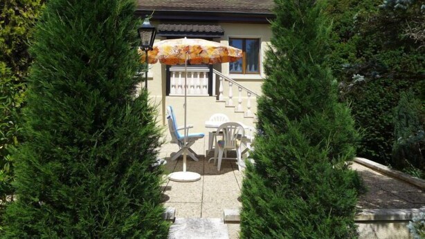A house with a staircase leading to the entrance, surrounded by evergreen trees. - 5, chemin de la Pralay by Interhome (Geneva)