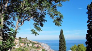 A coastal town with buildings, a beach, and a view of the sea.
