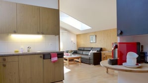 A modern kitchen with wooden cabinets, a built-in dishwasher, and a skylight. - Oltschiblick by Interhome (Brienzwiler)