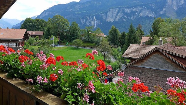A mountain village with traditional wooden houses, a green field, and a view of the mountains. - Oltschiblick by Interhome (Brienzwiler)