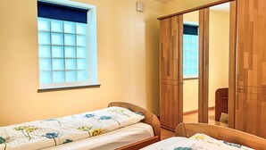 A bedroom with two single beds, a wardrobe, and a window with blinds. - Zum Trichter by Interhome (Palzem)