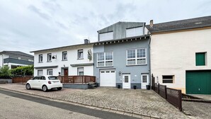 A residential street with houses, a parked white car, and a cobblestone driveway. - Zum Trichter by Interhome (Palzem)