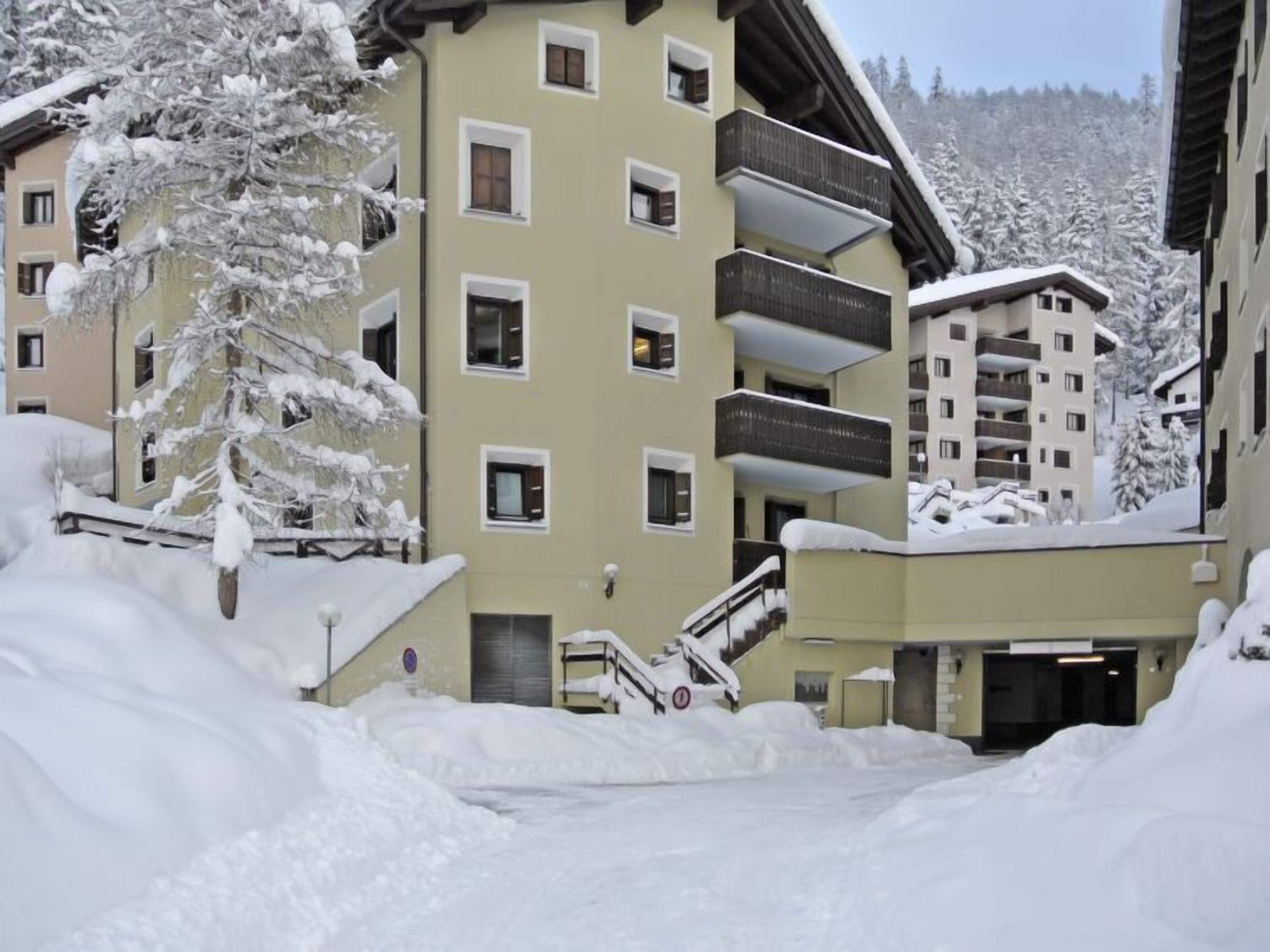 A multi-story hotel with balconies and a snow-covered landscape.
