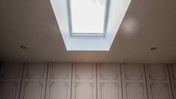 A skylight in a room with patterned walls.