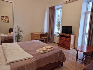 A hotel room with a bed, a TV, a desk, and a chair. - Home-Hotel Kostelnaya 3 (Kyiv)