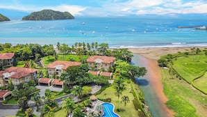 Et resort med flere bygninger, en swimmingpool og en strand.