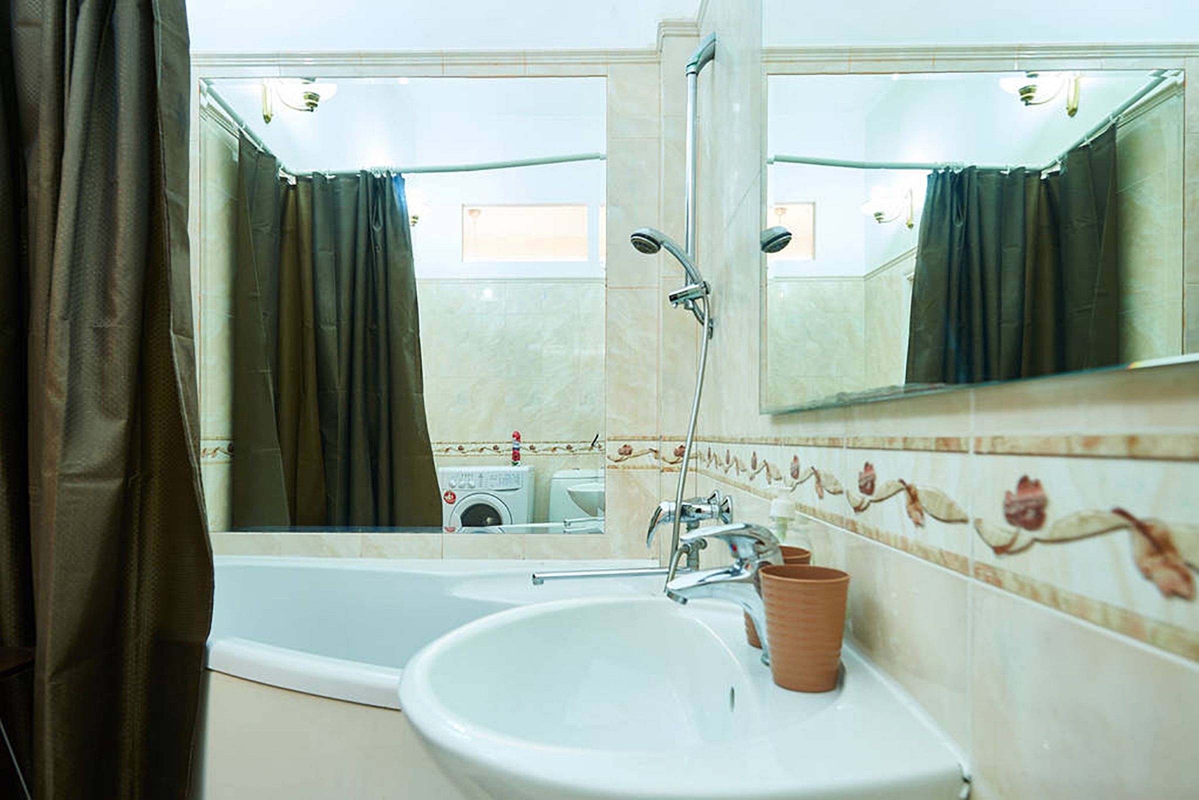 A bathroom with a bathtub, a sink, and a mirror.