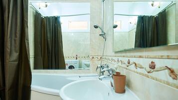A bathroom with a bathtub, a sink, and a mirror.