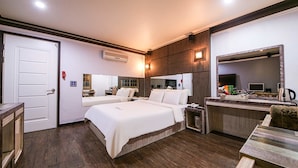 Une chambre d’hôtel avec deux lits, un bureau, un miroir et une petite kitchenette.