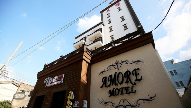 Un bâtiment sur lequel on peut voir une enseigne indiquant « Amore Motel ».