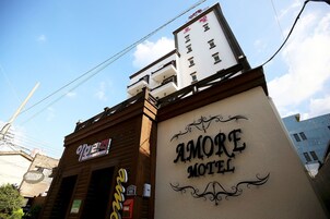 Un edificio con el cartel de Amore Motel.