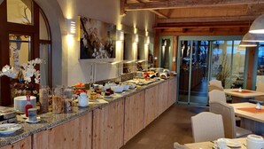 A buffet area with various food items and a wooden counter. - Hotel NEUE HÖHE (Klingenberg)