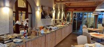 A buffet area with various food items and a wooden counter.