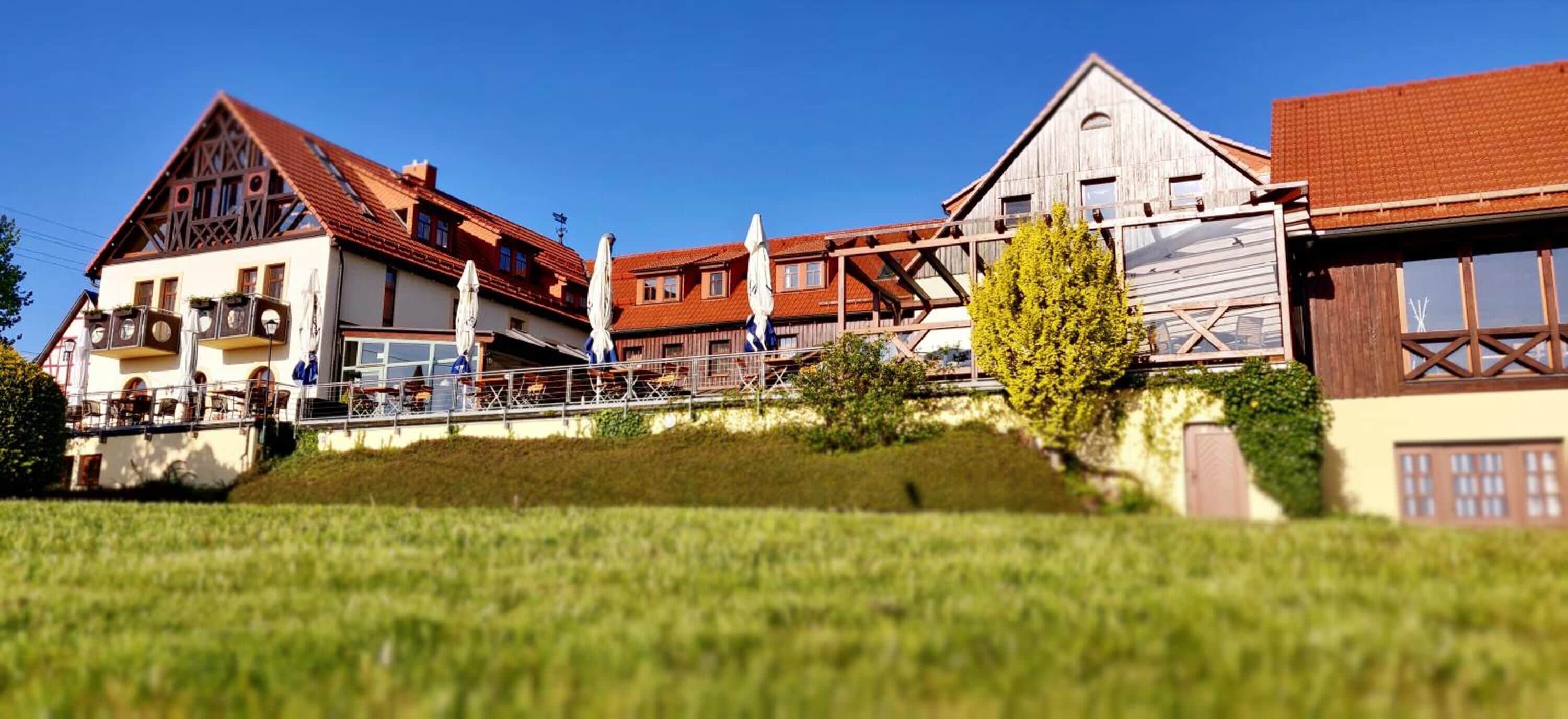 A traditional European building with a balcony, a wooden facade, and a red-tiled roof.
