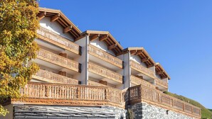 A multi-story building with wooden balconies and stone walls.