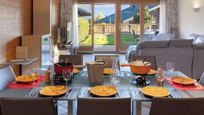 A dining area with a table set for six, a sofa, and a TV in the background.