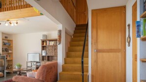Un escalier avec une rampe en bois menant à une porte fermée.
