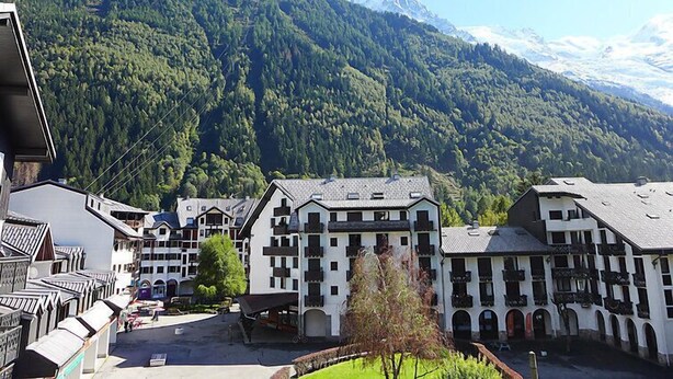 Un bâtiment de style chalet traditionnel, doté d’une façade symétrique, de nombreux balcons et d’une cour intérieure.
