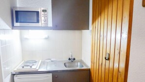 Une cuisine compacte équipée d’un four à micro-ondes, d’un évier et d’un petit réfrigérateur.