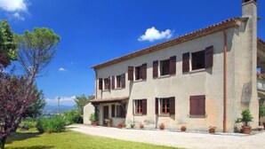 A two-story house with a tiled roof, multiple windows with shutters, and a chimney. - Montebello by Interhome (Città di Castello)