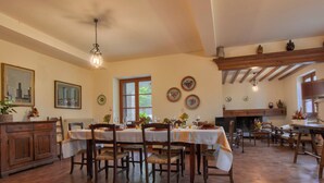 A spacious dining area with a large table set for a meal, surrounded by wooden chairs. - Montebello by Interhome (Città di Castello)