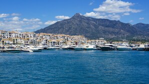 A marina with boats docked, a coastal town with white buildings, and a mountain in the background. - Marbella Real by Interhome (Marbella)